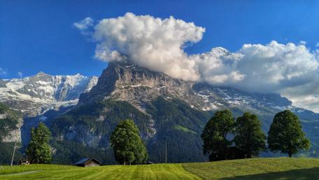 Cloud Crowned Bernese Alps Over Grindelwald Meadows Switzerland wallpaper