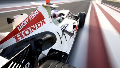 High Speed Formula One Car Racing Through a Blurred Track in 4K wallpaper
