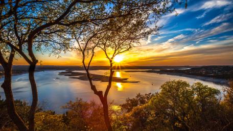 Golden Sunset Over Lake Travis Through Hill Country Trees wallpaper