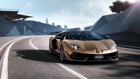 Lamborghini Aventador SVJ Roadster Racing Through Modern City Curves wallpaper