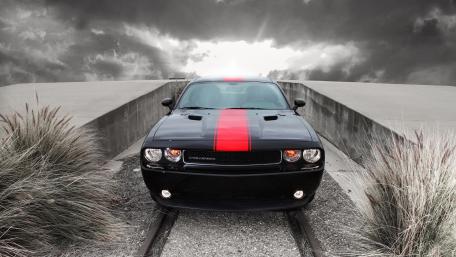 Dodge Challenger Muscle Car with Red Racing Stripe Under Stormy Skies wallpaper