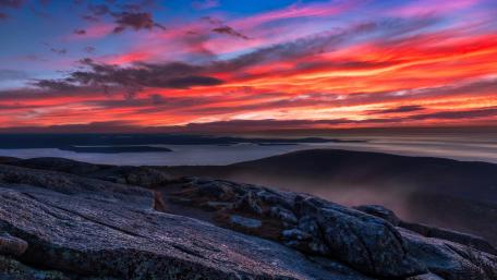 Crimson Afterglow Over Rocky Summit and Distant Horizon wallpaper