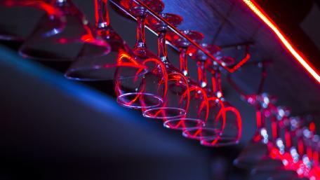 Neon Reflections on Hanging Wine Glasses in Nightclub Glow wallpaper
