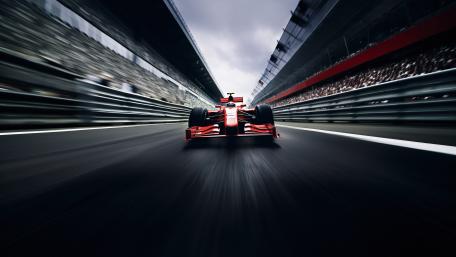 Red Formula One Car Blazing Through a Stadium Straight wallpaper