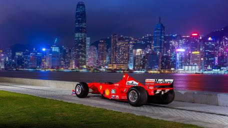 Ferrari Formula One Racer Under Neon Skyline Night wallpaper