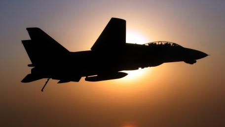 Silhouetted Fighter Jet Against a Burning Sunset Sky wallpaper