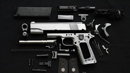 Disassembled Tactical Handgun Parts on Dark Workbench Flat Lay wallpaper