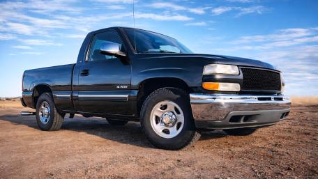 Sleek Black Pickup Truck Under Wide Blue Sky 4K Wallpaper wallpaper