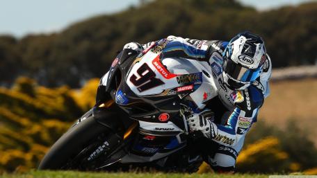 Suzuki GSXR Racer Carving a Fast Corner in Full Attack wallpaper