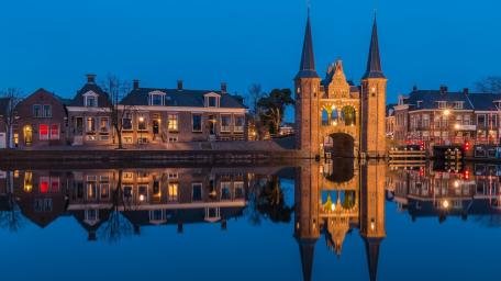 Waterpoort at Dusk Reflected in the Calm Canal of Sneek wallpaper