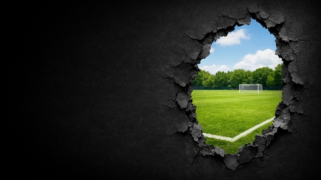 Breakthrough View to the Soccer Pitch Beyond the Wall wallpaper
