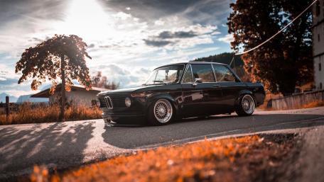 Sunlit Vintage BMW Classic Car on a Quiet Country Road wallpaper