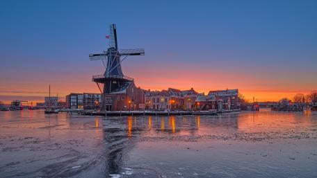 Sunset Serenity at De Adriaan Windmill on the Spaarne River wallpaper