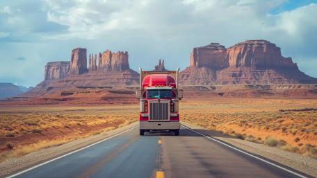 Red Semi Truck Cruising Desert Highway in Monument Valley 5K wallpaper