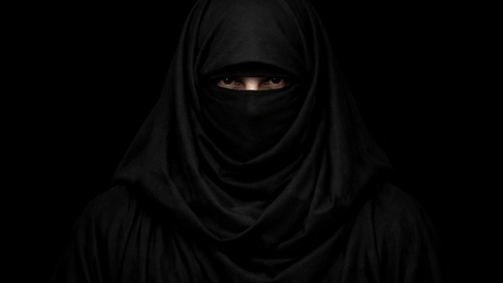 Silent Gaze in Shadowed Niqab Minimal Portrait on Black Background wallpaper
