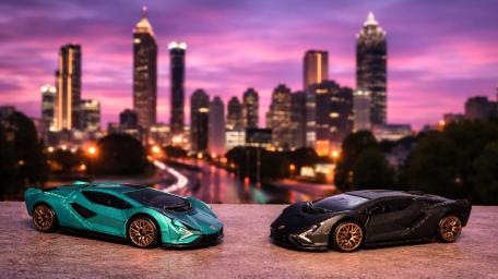 Twin Lamborghini Sián Model Cars Against a Neon City Skyline wallpaper