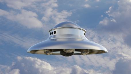 Silver UFO Gliding Through Dreamy Clouds wallpaper