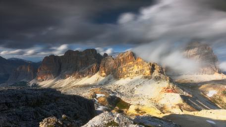 Sunlit Dolomites Beneath Sweeping Alpine Clouds wallpaper