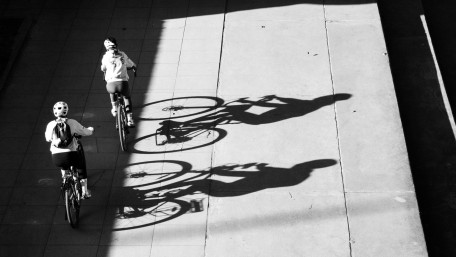 Urban Cyclists in Bold Shadow Play wallpaper