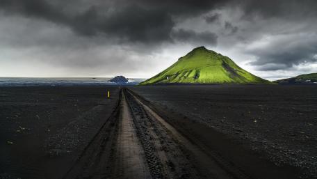Moss Green Volcano Under Stormy Icelandic Skies wallpaper