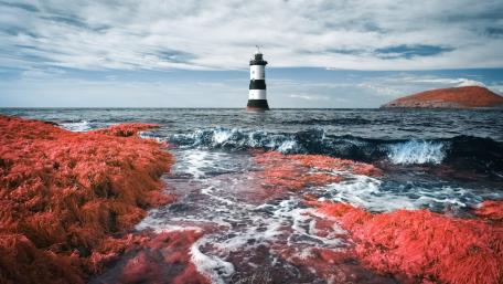 Penmon Point Lighthouse Over Turquoise Waters wallpaper