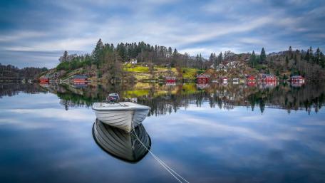 Serene Boat Reflection in Norwegian Fjord Village wallpaper