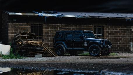 Rugged Black Jeep Wrangler in Industrial Setting wallpaper