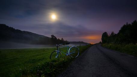 Twilight Bicycle Ride in a Moonlit Field wallpaper