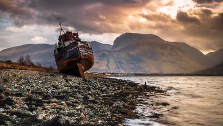 Rusty Shipwreck on a Rocky Coast wallpaper