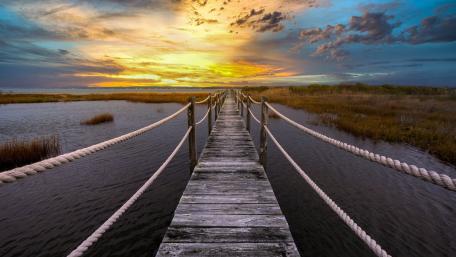 Sunset Boardwalk Over Tranquil Wetland wallpaper