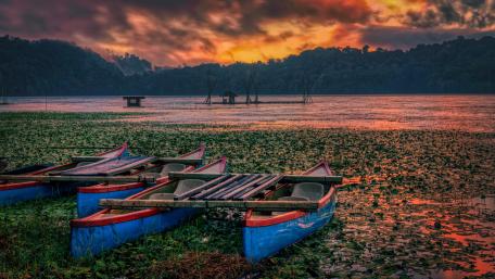 Serene Sunset Over Calm Lake with Canoes wallpaper