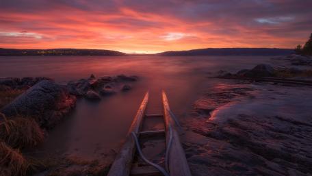 Pink Sunset Over Calm Lake Shoreline wallpaper