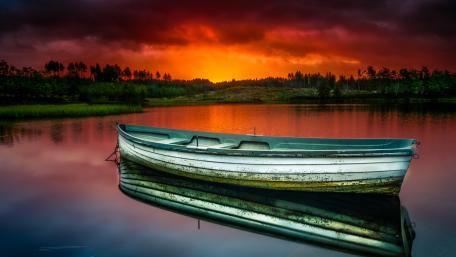 Sunset Rowboat on Tranquil Lake wallpaper