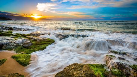 Sunlit Waves Over Mossy Shoreline wallpaper