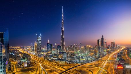Dubai Skyline Glowing Above Busy Expressways wallpaper