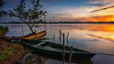 Sunrise Boats on a Tranquil Lakeshore wallpaper
