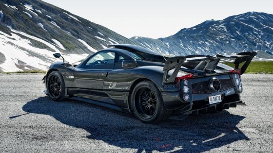 Sleek Black Sports Car Powerhouse on Snowy Mountain Road wallpaper