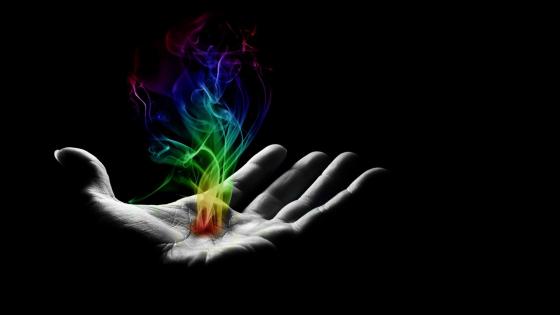 Rainbow colored smoke on hand wallpaper