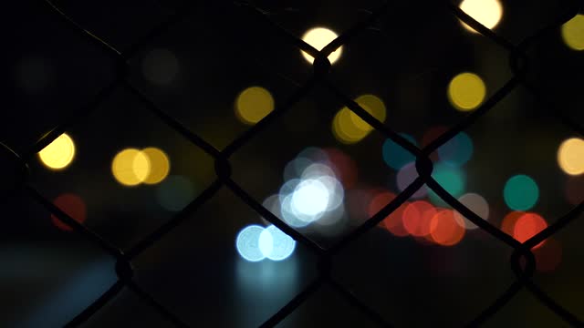 Blurred lights through wire fence live wallpaper