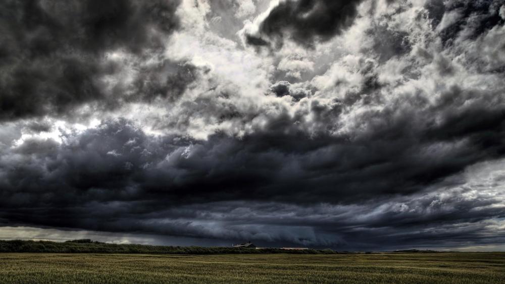 Stormy clouds above the field wallpaper