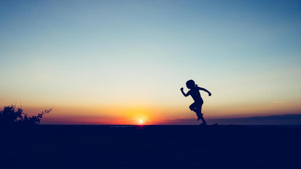 Jumping girl silhouette in the sunset wallpaper