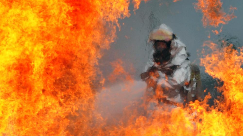 U.S. Air Force Firefighter Sprays Water on a Fire wallpaper