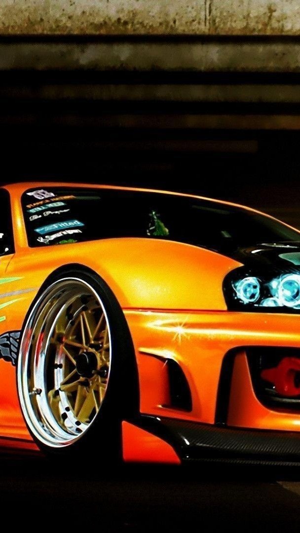 Gleaming Orange Supra in Urban Shadows - backiee