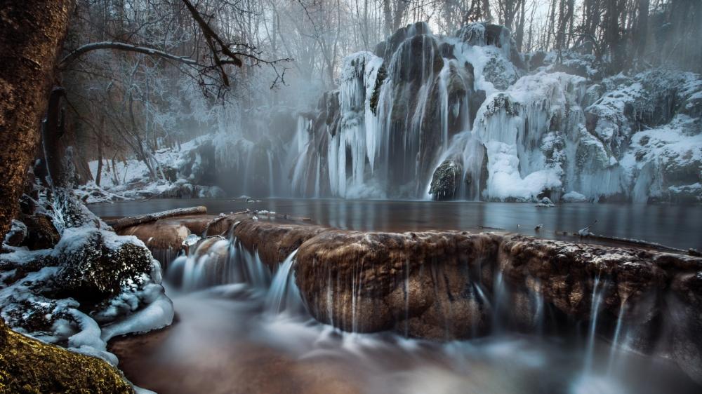Fog is taking over a winter waterfall wallpaper